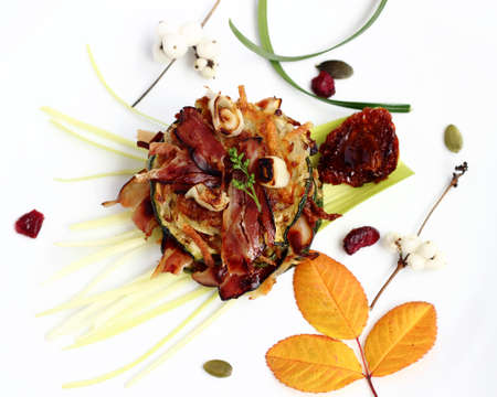 Delicious appetizer with fried potato pancakes, zucchini slices and crispy baconの写真素材