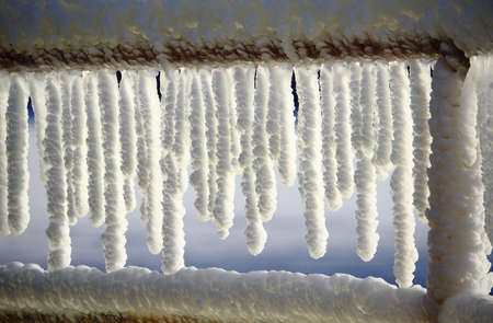 Frozen icicles on the railingの写真素材