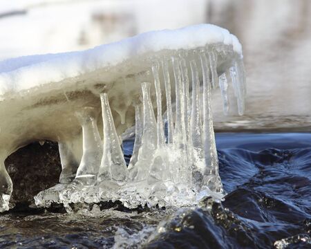 Landscape with ice icicles on the river shoreの写真素材