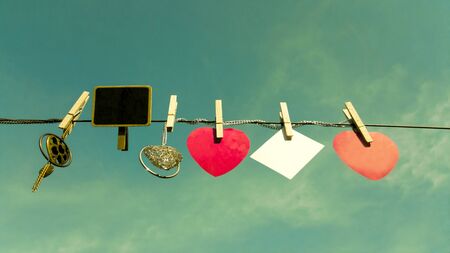 Valentine day vintage background . Red heart and blank white cards hanging on a clothesline against...