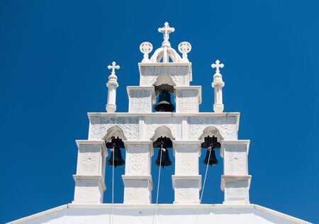 White Bell Tower against blue Sky in Greeceの写真素材