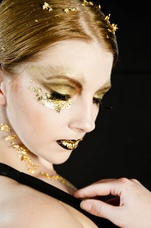 Portrait of a blonde woman with gold on her face