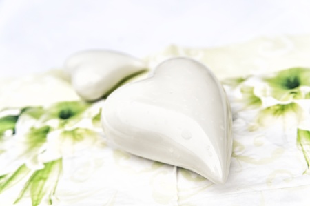 Two pottery white hearts with water dropsの写真素材