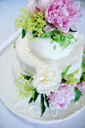 multi level white wedding cake with pink rosesの写真素材