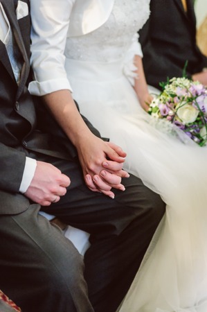 Bridal couple holding hands during wedding ceremonyの写真素材
