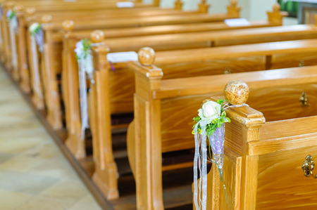 Wooden church bench with flower decoration for a wedding ceremonyの写真素材