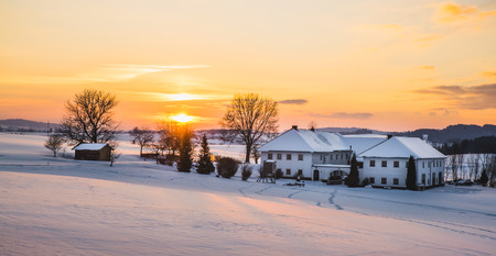 Farmhouse in a winter landscape at sunrise taken in upper austriaの写真素材