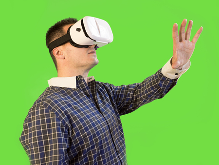 Man by Green Screen with Hand Extended Wearing VR 360 Glassesの写真素材