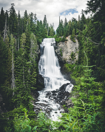 Dreamy slow shutter flowing river over multi tier waterfall by Whistler Canadaの写真素材