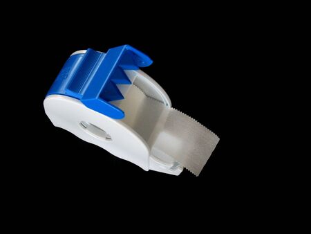 Medical sticking plaster in a dispenser. Isolated on black.の写真素材