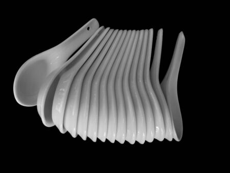 White, ceramic oriental spoons. Isolated on black.の写真素材