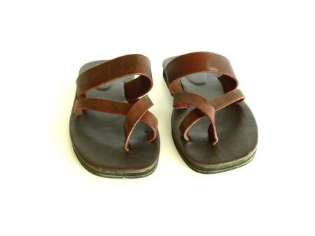 a pair of flat, brown leather sandals. Toes to viewer. Isolated on white.の写真素材