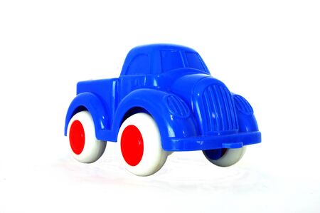 A bright blue toy truck with white tyres and red wheelsの写真素材