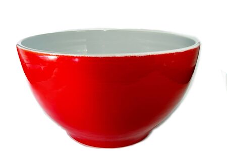 a large red ceramic salad bowl with a white interior.の写真素材