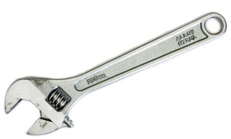 An Adjustable wrench. Dirty from use. Isolated on white