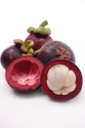 Mangosteen fruit and cross section showing the thick purple skin and white flesh of the queen of fruits.の写真素材