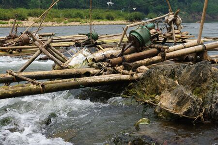 Improvised run-of-stream micro hydro electricity generation. Using boat propellers in rapids driving shafts to electric motors, all supported on bamboo scaffolding. Nam Ou River, Laosの写真素材
