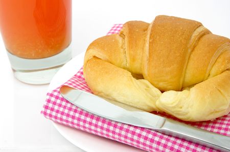 A light, healthy breakfast of fruit juice and a croissant. High key shotの写真素材