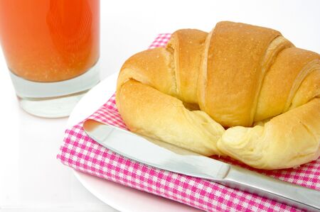 A light, healthy breakfast of fruit juice and a croissant. High key shotの写真素材