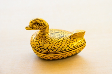 Wooden casket with gold leaf on white floorの写真素材