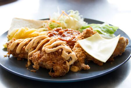 Fried chicken with cheese,fries and mustard   on a plateの写真素材