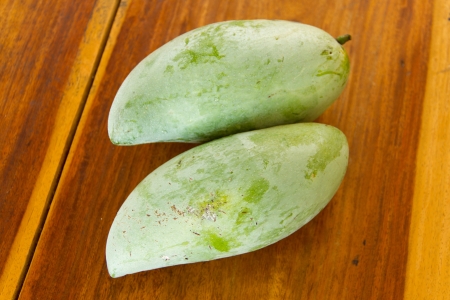 Two mangoes on wooden tableの写真素材
