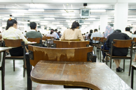Students sitting in an exam hall doing an exam in universityのeditorial素材