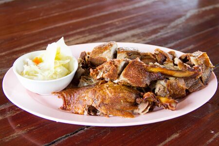 Duck fried in white dish on wooden tableの写真素材