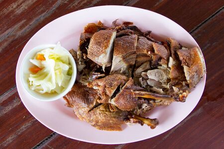 Duck fried in white dish on wooden tableの写真素材