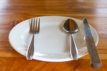 Dishes, utensils and cutlery placed on wooden table