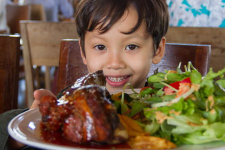 little cute boy show the foodの写真素材
