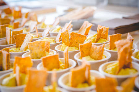 Salmorejo cups with a transparent plastic spoon inside and a man's hand is holding a cupの写真素材