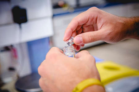 laboratory staff observe the reaction of a liquid in a glass jar