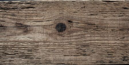 Closeup photo of an old tree. Wooden background. Brown board with cracks and reflections.