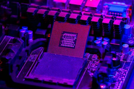 The processor on the motherboard in neon light. Computer parts. Close-up photoの写真素材
