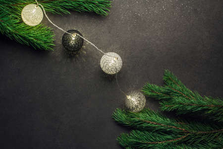 Garland on pine branches on a black background.