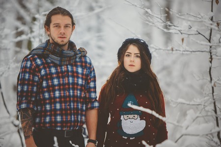 Happy couple in winter clothes walking outdoors in parkの写真素材