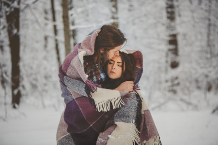 Loving couple in snowy winter forestの写真素材
