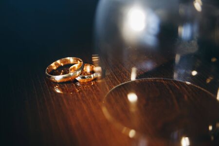 Two golden wedding rings isolated on the table, wedding rings background conceptの写真素材