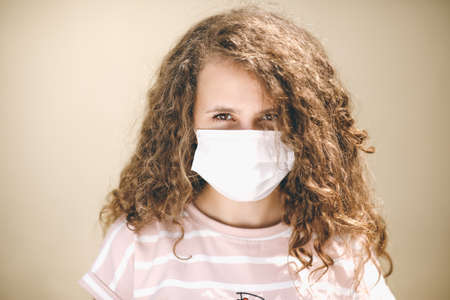 A Young Girl With Curly Hair Wears A Mask To Protect Coronavirus