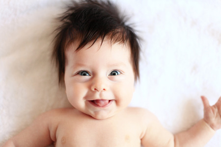 Beautiful expressive adorable happy cute laughing smiling baby infant face showing tongue  