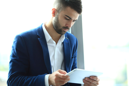 Businessman using his tablet in the officeの写真素材