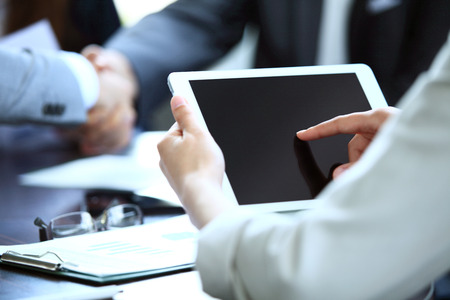 Close-up image of an office worker using a touchpad to analyze statistical dataの写真素材