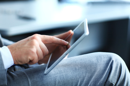 Close-up image of an office worker using a touchpad to analyze statistical data