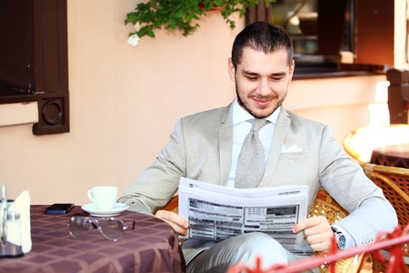 Handsome man reading a newspaperの写真素材