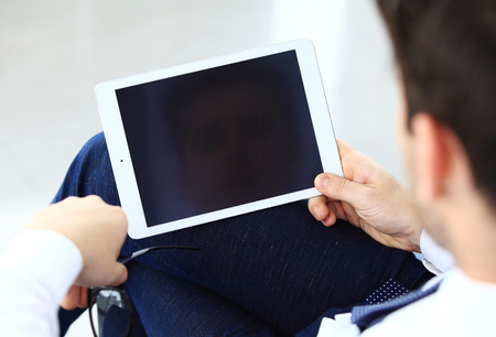 Close-up image of an office worker using a touchpad to analyze statistical dataの写真素材