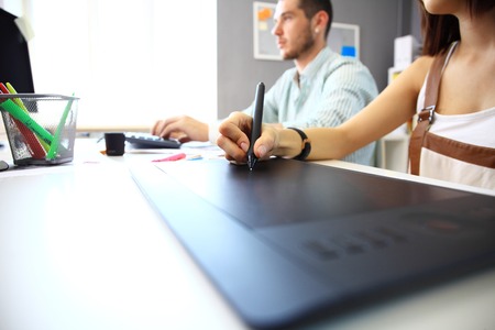 Graphic designer using digital tablet and computer in the office