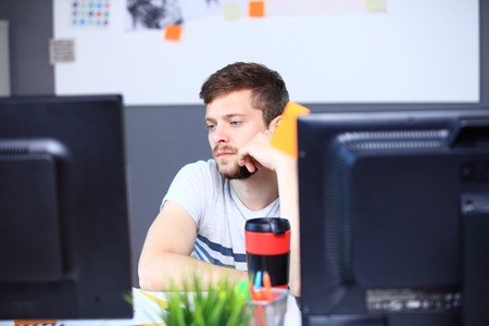 Portrait of smiling male photo editor using computer in the office