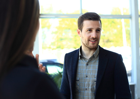 Happy smart business man with team mates discussing in the backgroundの写真素材