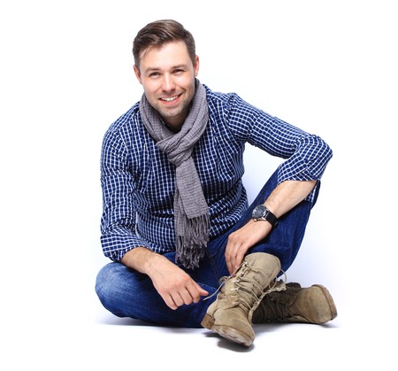 Flirtatious man sitting on the floorの写真素材